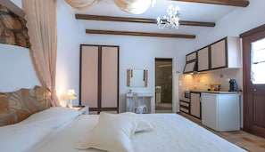 A bedroom with a bed, a nightstand, a lamp, and a window with curtains.