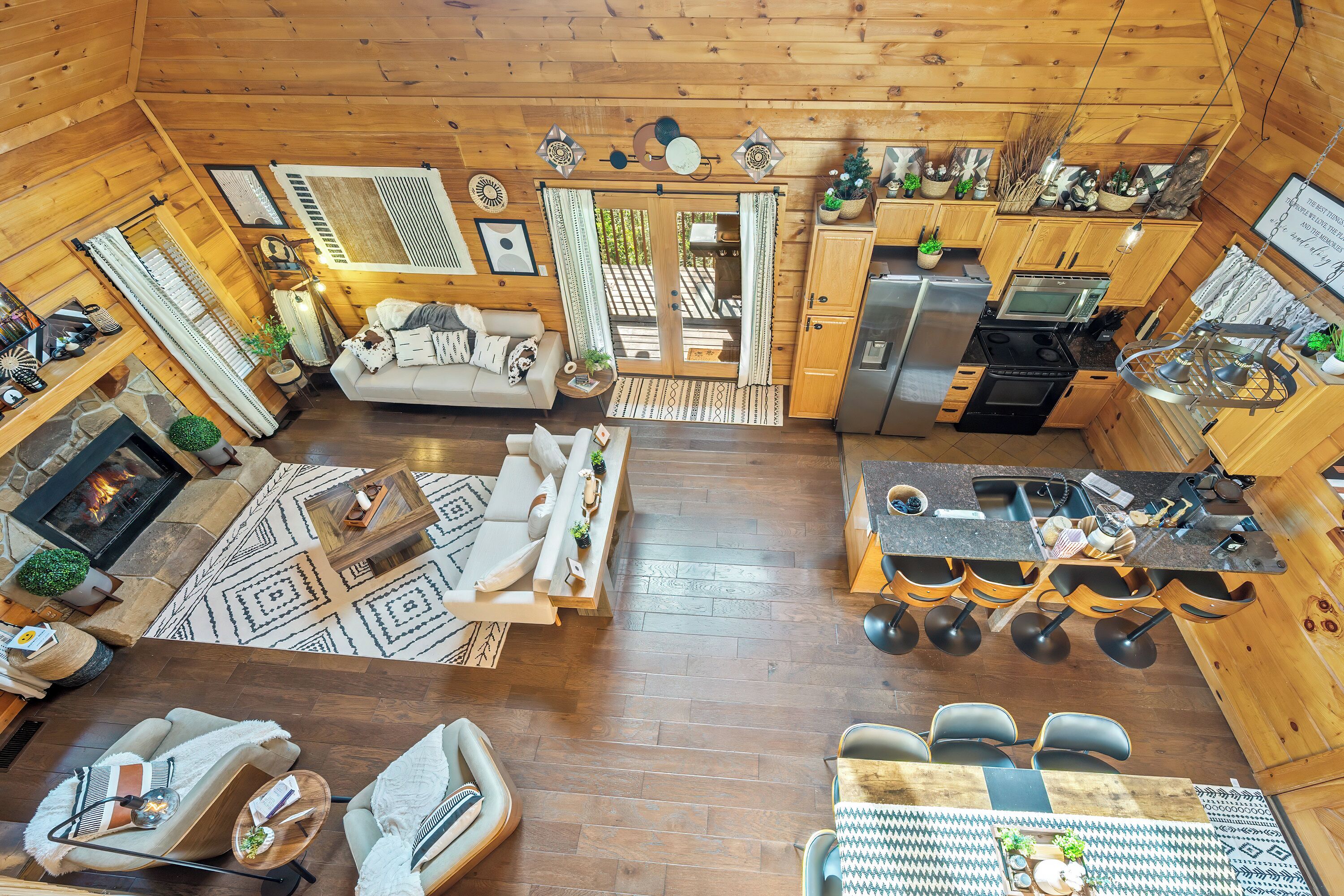 A spacious log cabin with a living area, dining space, kitchen, and a fireplace.