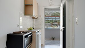 Uma cozinha moderna com forno embutido, pia e janela com vista para uma varanda.