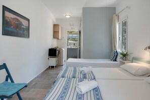 A bedroom with two beds, a desk, a chair, and a window.
