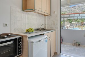 Een compacte keuken met een ingebouwde oven, een kleine vaatwasser en een spoelbak.