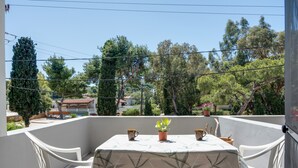 A balcony with a table, chairs, and potted plants. - Apartment 'Studio 1' with Mountain View, Wi-Fi and Air Conditioning (Panormos Kalymnos)