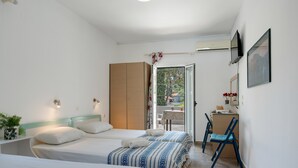 A bedroom with two beds, a desk, and a chair. - Apartment 'Studio 1' with Mountain View, Wi-Fi and Air Conditioning (Panormos Kalymnos)