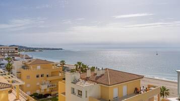 Zona residencial costera con edificios, una playa y cielo despejado.
