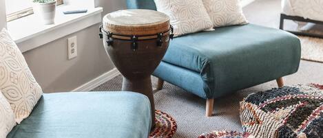 A room with a blue sofa, a drum, and a patterned rug.