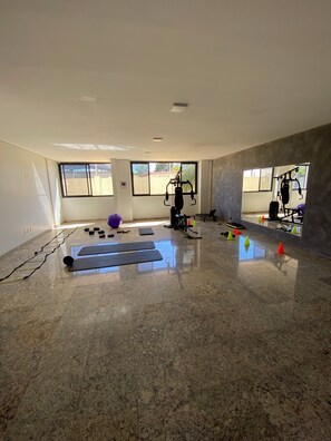A spacious room with a large window, exercise equipment, and a yoga mat. - Fully furnished apartment in the best block of Palmas. (Palmas)