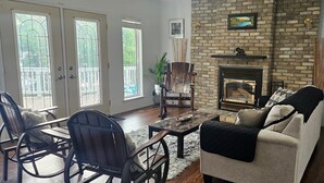 Una sala de estar con chimenea, un sofá, una mesa de centro y dos sillones.
