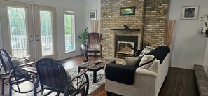Un salon avec une cheminée, un canapé, une table basse et deux fauteuils.