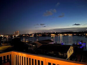 A waterfront view at dusk with buildings and boats. - Top-Floor Canal View Condo w/ Pool, Steps to Beach (Carolina Beach)