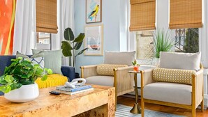 A living room with a sofa, armchairs, a coffee table, and a bookshelf.