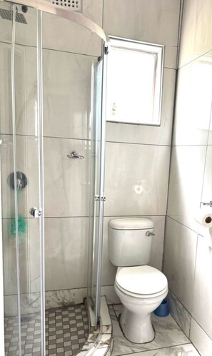 Bathroom features a glass shower enclosure and a tiled floor with a checkered pattern.