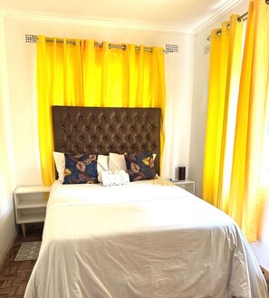 Classic design with a large bed, tufted headboard, and comfortable pillows.