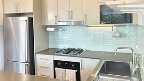 Eine moderne Küche mit Edelstahlgeräten, einem Gasherd und einem eingebauten Backofen.
