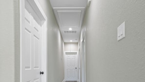 A hallway with white doors and a wooden floor.