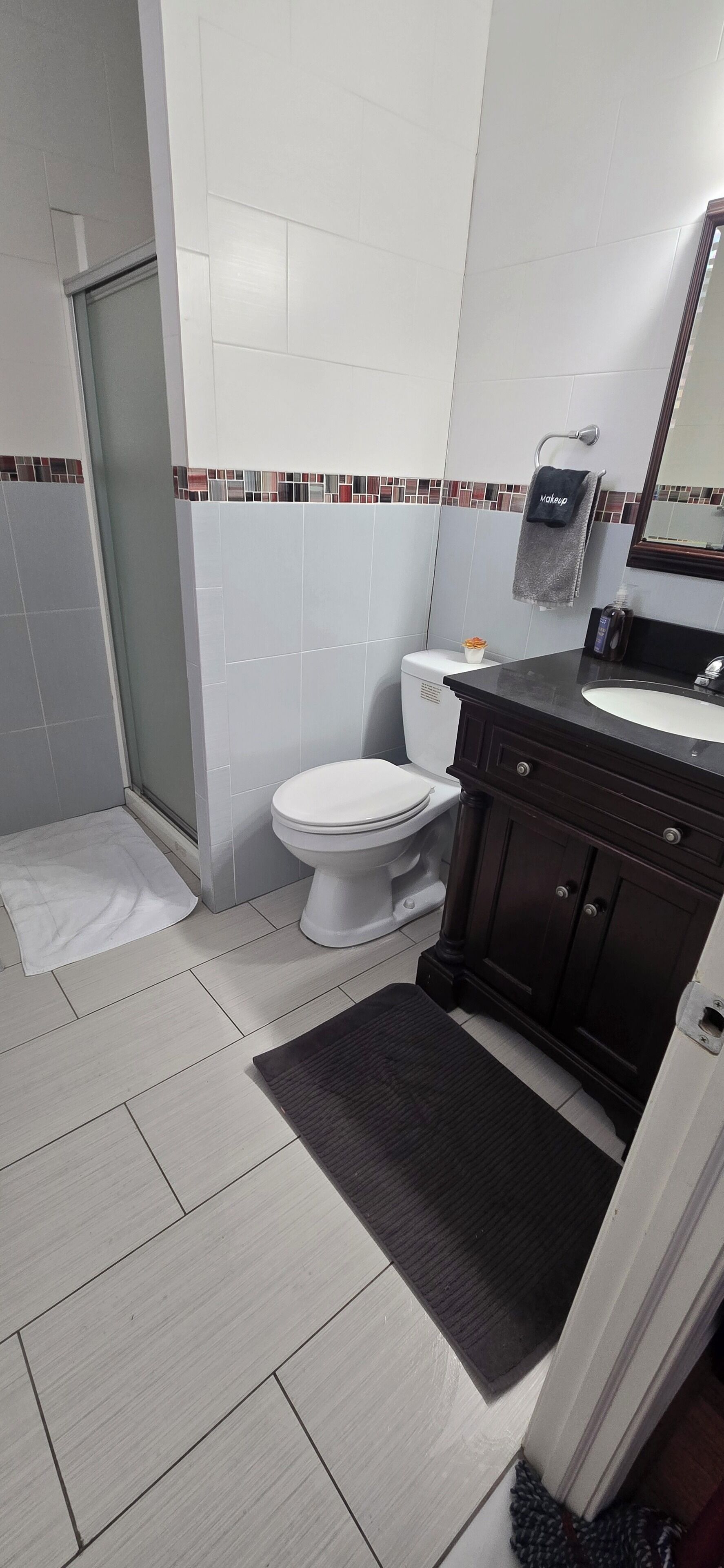 A bathroom with a toilet, a sink, and a shower area.