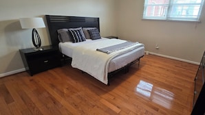 A bedroom with a bed, nightstands, a lamp, a dresser, and a window. - Spacious 3-bedroom apartment in charming Philadelphia with AC, WiFi (Philadelphia)