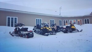 Un edificio con diversi motoslitte parcheggiate davanti.