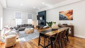 A modern living room with a sofa, coffee table, and dining area.