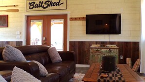 A living room with a brown leather couch, a coffee table, and a sign that reads "Bait Shed".