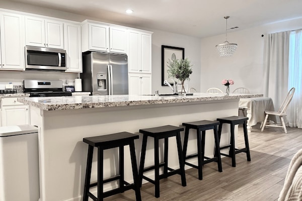 Kitchen with large island with 4 stools; upgraded cabinets, granite counters