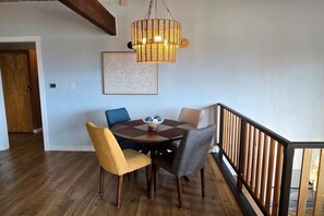 A dining area with a round table, four chairs, a hanging light fixture, and a framed artwork on the wall. - Diamond Point~Canal Views! Peaceful with Game Room (Sequim)