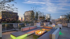 An outdoor seating area with fire pits and a view of the city skyline. - Resort Condo near SXSW (Austin)