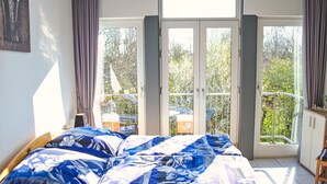 A bedroom with a bed, a window, and a balcony. - Tossens by Interhome (Tossens)