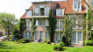 A multi-story residential building with a brick facade, large windows, and a balcony. - Tossens by Interhome (Tossens)