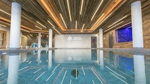 A spacious indoor pool area with a wooden ceiling and a sign for Chalet Altitude. - Chalet in Paradiski With Stunning Ski Views (Bourg-Saint-Maurice)