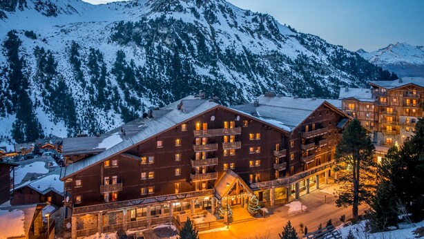 A multi-story wooden lodge with balconies, a ski lift, and a mountain backdrop. - Chalet in Paradiski With Stunning Ski Views (Bourg-Saint-Maurice)