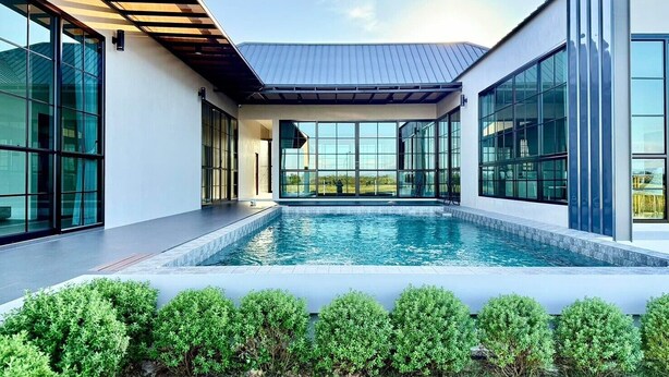 A modern house with a swimming pool, large windows, and a well-maintained garden. - Chomnok Chomna Pool villa (Khlung)