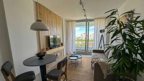 Un salon moderne comprenant un coin repas, un canapé, une table basse et une grande fenêtre offrant une belle vue.