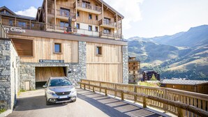 A multi-story wooden building with balconies, a stone facade, and a sign for "PARKING NORD". - Apartment in France With Heated Pool & Spa (Les Belleville)