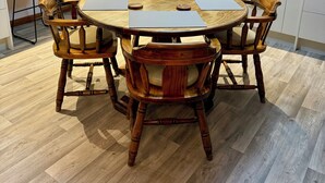 A modern kitchen with a round dining table, wooden chairs, and a built-in dishwasher. - Comfort at Stag Lodge Just Mins Walk to Queens Park & Down Town Invercargill (Invercargill)