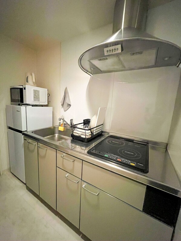 A compact kitchen with a microwave, a small refrigerator, a sink, and a stove. - Walking to Dotonbori, the heart of Osaka (大阪市)