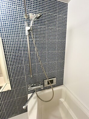 Et badeværelse med bruser og toilet.