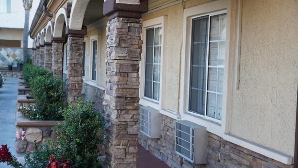 A building with stone pillars and large windows. - Avenue Motel (Gardena)