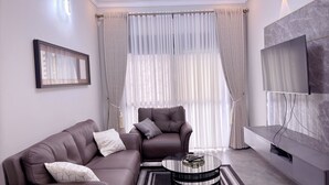 Un salon moderne avec un canapé, un fauteuil et une table basse.