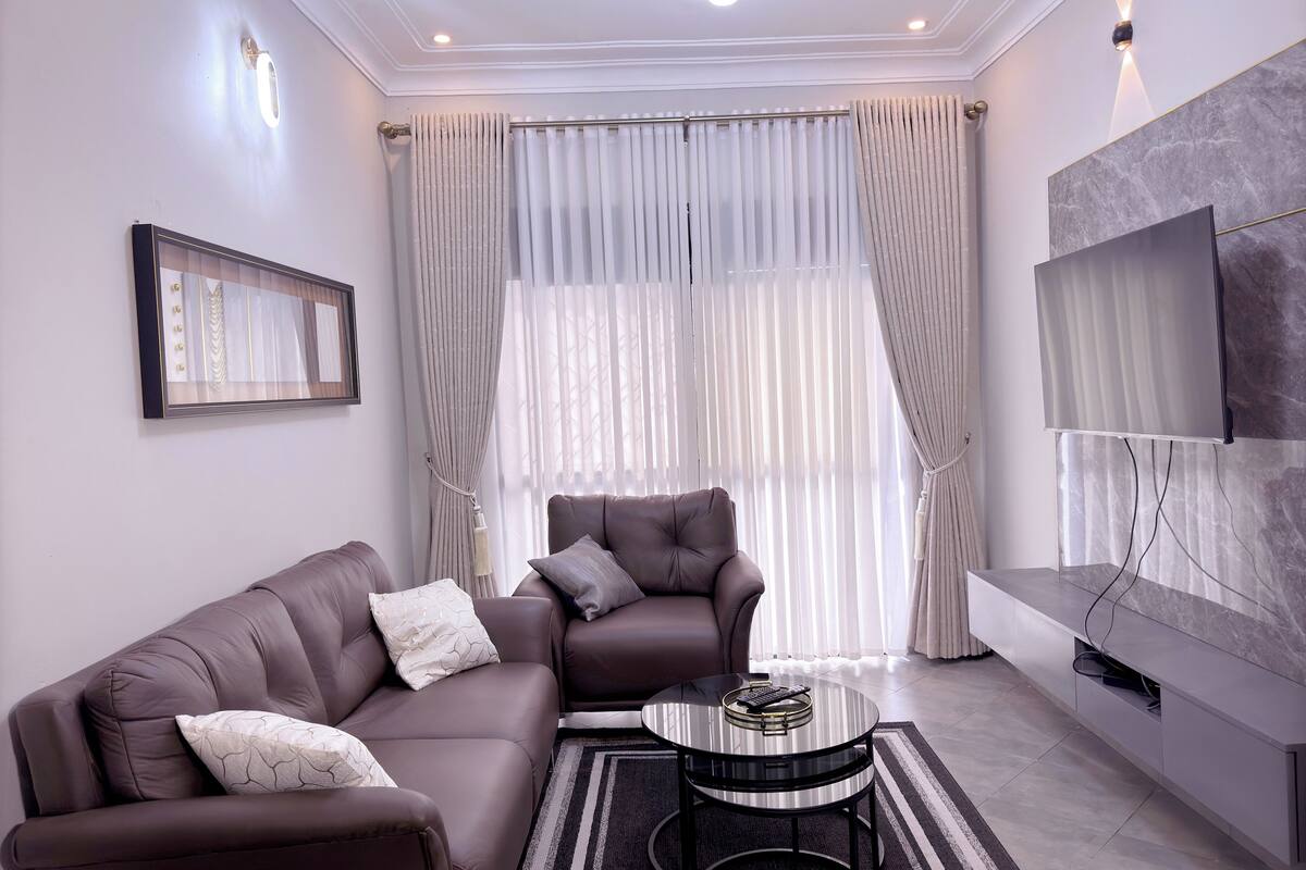 A modern living room with a sofa, armchair, and a coffee table.
