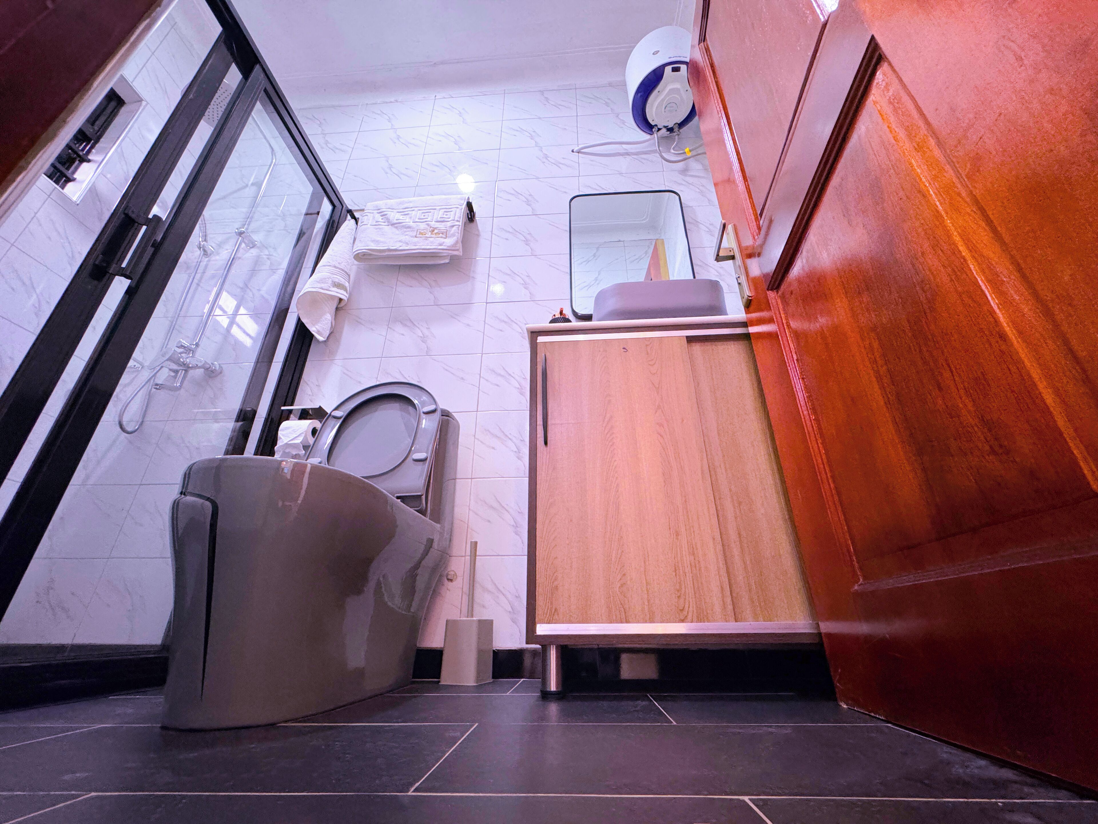Un baño pequeño con inodoro, ducha y lavamanos.