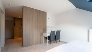 Un dormitorio moderno con una cama, un escritorio y dos sillas.