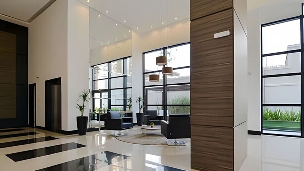 A modern lobby with a glossy floor, large windows, and contemporary furniture. - Studio prox shopping Curitiba Wifi, TV a Cabo e ar (Curitiba)