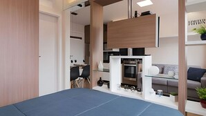 A modern, compact living space with a kitchenette, a dining area, and a seating area. - Studio prox shopping Curitiba Wifi, TV a Cabo e ar (Curitiba)