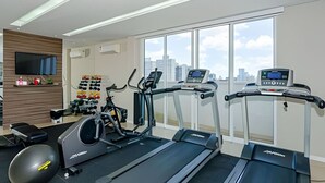 A modern gym with treadmills, an elliptical, and a variety of weights. - Apartamento completo na Av. Iguaçu — garagem, rooftop e localização estratégica (Curitiba)