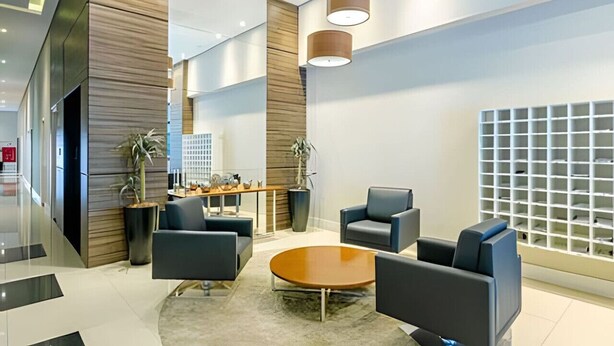 A modern lobby with seating, a reception desk, and a decorative wall. - Apartamento completo na Av. Iguaçu — garagem, rooftop e localização estratégica (Curitiba)