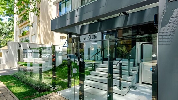 Un edificio moderno con entrada de vidrio, una escalera visible y un letrero que dice "easyLife".