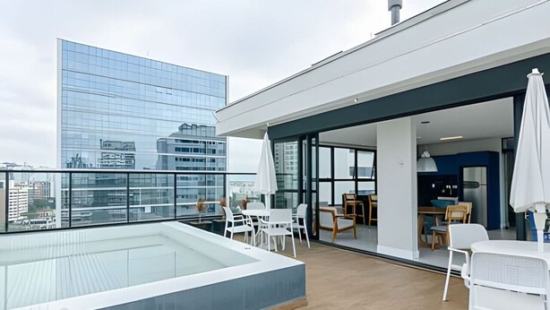 Une terrasse sur le toit avec une piscine, un espace repas et une vue sur la ville.