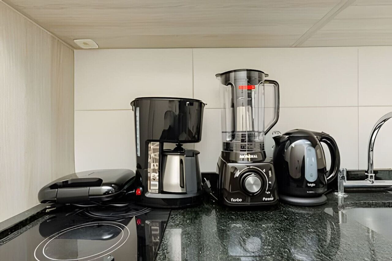 A kitchen with a coffee maker, blender, and kettle on the counter.