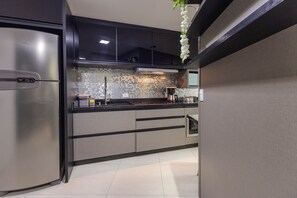 Quarto com TV smart no painel e janela com vista da cidade de Curitiba - 7th Avenue Studio · 15º andar · Vista e Garagem (Curitiba)
