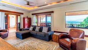 A spacious living room with a large sectional sofa, a red cabinet, and a view of the outdoors.